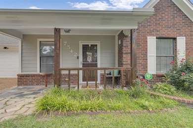 View of exterior entry featuring brick siding and a porch