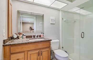 Bathroom featuring walk in shower, vanity, and toi