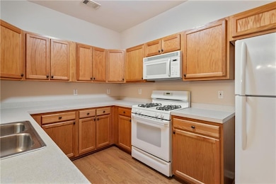 Kitchen with light countertops, a sink, light wood