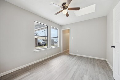 Unfurnished room with a skylight, ceiling fan, wo
