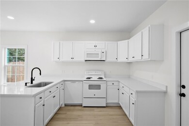 Kitchen with sink, white appliances, white cabinet