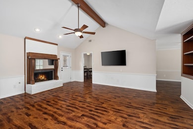 Unfurnished living room featuring a fireplace, ceiling fan, wainscoting, dark wood finished floors, and recessed lighting
