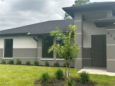 Entrance to property with a shingled roof, a lawn,