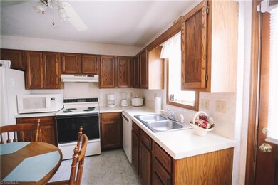 Double sink overlooks back deck area.  Lots of counter space for food preparation and cabinets for all your storage needs.