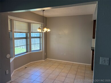 Spare room with a textured ceiling, a chandelier,