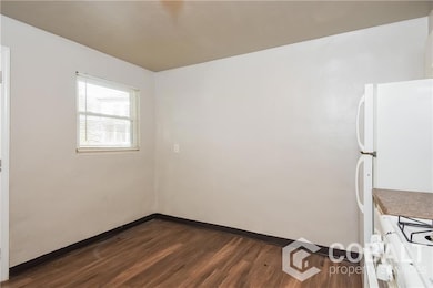 Unfurnished room featuring dark wood-type flooring