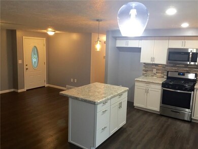 Beautiful lighting and island, metal front door, a