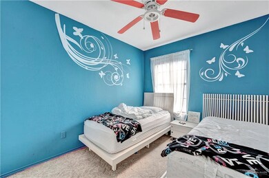 Carpeted bedroom featuring ceiling fan