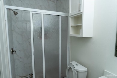 Bathroom with a shower stall and toilet