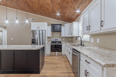 Kitchen with wood ceiling, a sink, stainless steel