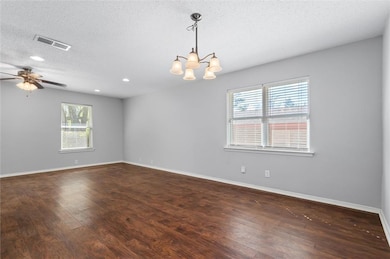 Empty room featuring dark wood-style floors, reces