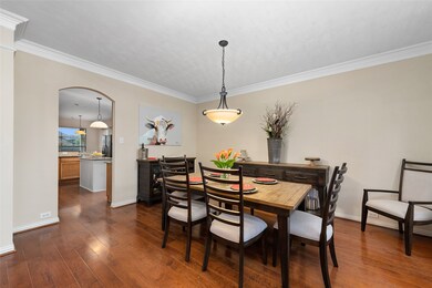 The dining room is easily accessible from the kitchen through the stylish arched transition. The continuous engineered hardwoods add to the visual appeal of this space.