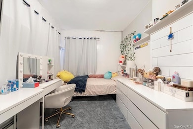 Bedroom featuring dark carpet and a desk