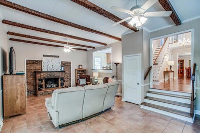 Living room with overhead beams & a gas fireplace.