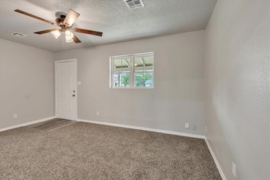 Unfurnished room featuring carpet floors, a ceiling fan, a textured ceiling, and baseboards