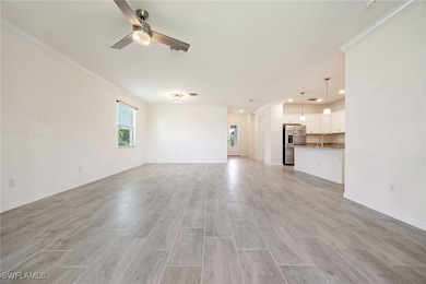 Unfurnished living room featuring crown molding, a