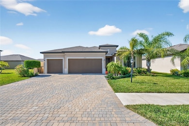 Prairie-style house featuring a front lawn, stucco siding, and decorative driveway