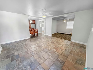 Unfurnished room featuring stone finish flooring and a ceiling fan