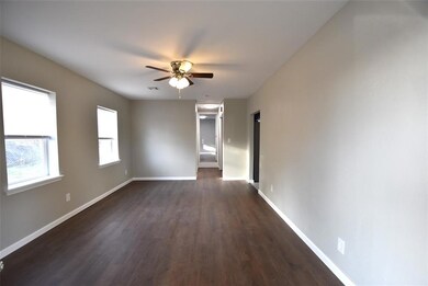 Empty room featuring ceiling fan and dark wood lam