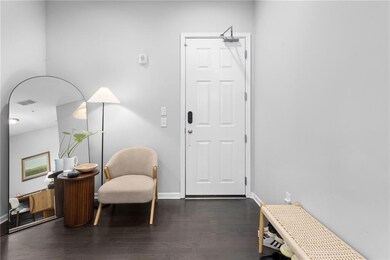Sitting room featuring dark wood-style flooring and baseboards