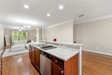 Kitchen with dishwasher, ornamental molding, a chandelier, light wood finished floors, and open floor plan
