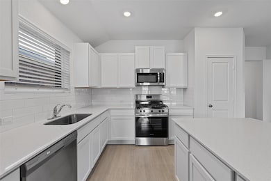 Kitchen featuring stainless steel appliances, lig