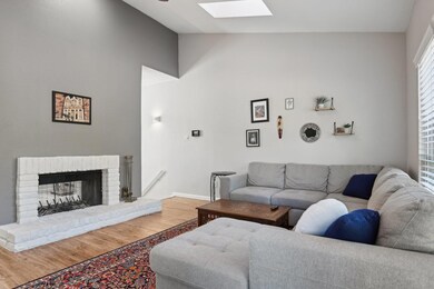 Living room featuring lofted ceiling with skylight