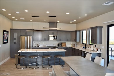 Kitchen featuring a center island, stainless steel appliances recessed lighting, and wood look tile flooring.