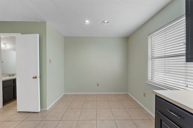 Unfurnished dining area featuring a textured ceiling, light tile patterned floors, and recessed lighting