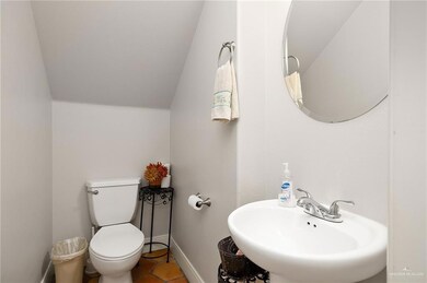 Bathroom featuring tile patterned floors, sink, vaulted ceiling, and toilet