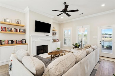 Check out the gas fireplace surrounded by floating cypress shelves, custom plantation shutters and the view of the pond.
