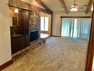 Living room with wood burning rock fireplace and w