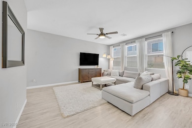 Living room with light wood finished floors and a ceiling fan