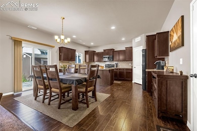 Dining room featuring dark wood-style flooring, a chandelier, and recessed lighting