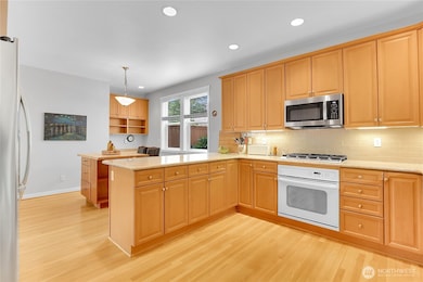 The hardwood flooring flows into the spacious dining area which is located off the kitchen.  Two large windows overlook the side of the home and fill the kitchen with natural light.