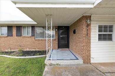 Ranch-style house with concrete driveway, brick siding, and an attached carport