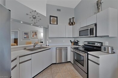 Kitchen with white cabinetry, high vaulted ceiling