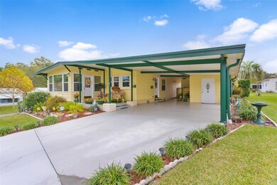 Side view of property, showcasing large carport, located on corner lot, and covered front porch to Florida Room
