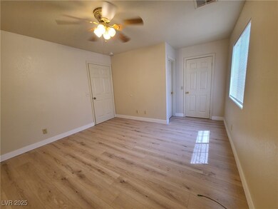 Empty room featuring a ceiling fan and light wood-