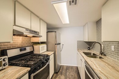 Kitchen featuring under cabinet range hood, stain
