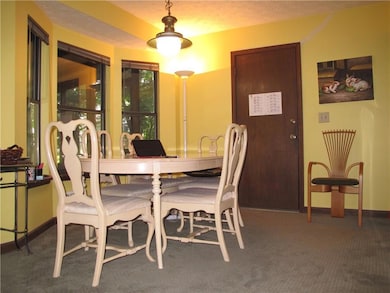 Dining space featuring carpet flooring and baseboa