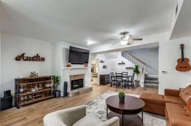 Living area with ceiling fan, stairs, wood finish