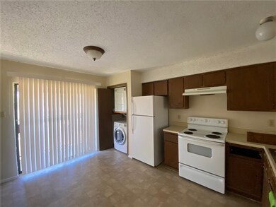 Kitchen with washer / dryer, white appliances, and