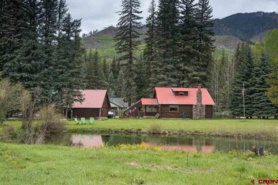 View Across Pond to Home and Detached Garage and G