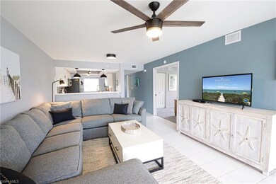 Living room featuring ceiling fan and light tile f