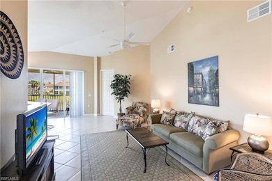 Living area with tile patterned floors, high vaulted ceiling, and a ceiling fan