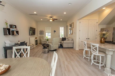 Dining space with a ceiling fan, light wood finish