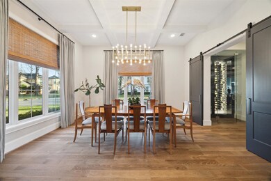 The formal dining room is a bright and inviting space, featuring expansive windows on two sides that flood the room with natural light, creating an elegant setting perfect for both intimate dinners and lively gatherings.