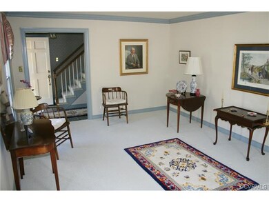 Large, sunny living room with wall-to-wall carpet.