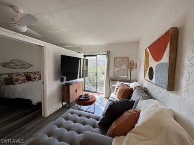 Living room with ceiling fan and dark hardwood / w